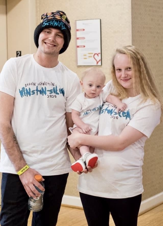 Family wearing matching white shirts, smiling together.