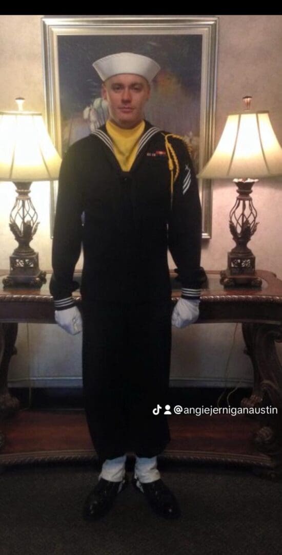 Person in naval uniform standing indoors.